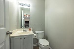 bathroom featuring toilet, vanity, and baseboards