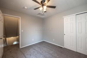 unfurnished bedroom featuring carpet flooring, baseboards, a closet, and ceiling fan