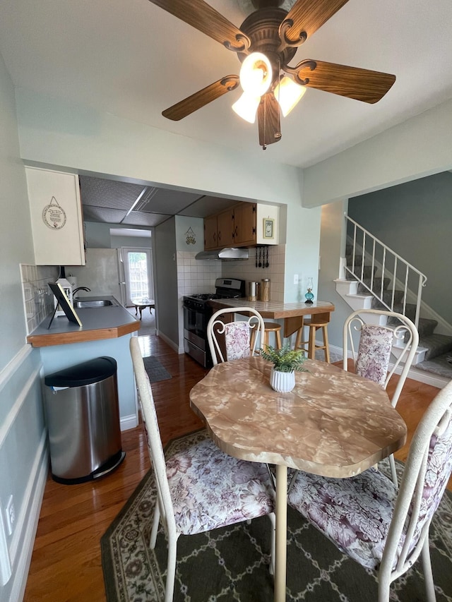 137 Tarryton Ct W Unit 24H, Columbus, OH 43228 - dining room with stairs, dark wood-style flooring, a ceiling fan, and baseboards