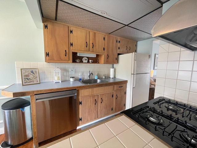 137 Tarryton Ct W Unit 24H, Columbus, OH 43228 - kitchen with stainless steel dishwasher, wall chimney range hood, gas range oven, freestanding refrigerator, and decorative backsplash