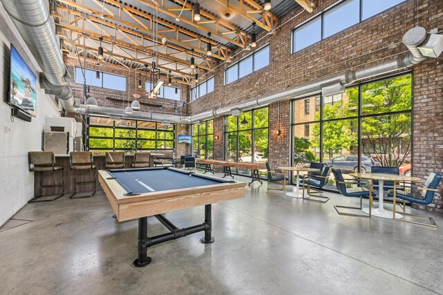 304 Cornelius St, Columbus, OH 43215 - rec room with a high ceiling, brick wall, billiards table, and finished concrete floors