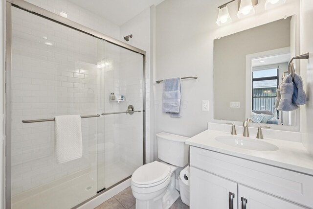 304 Cornelius St, Columbus, OH 43215 - ensuite bathroom featuring toilet, vanity, a stall shower, and tile patterned floors