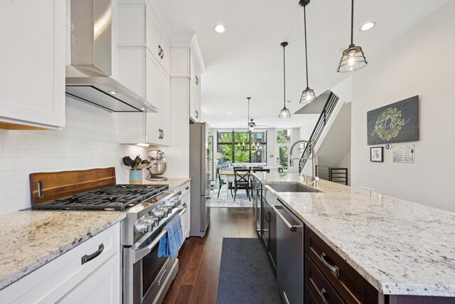 304 Cornelius St, Columbus, OH 43215 - kitchen with wall chimney exhaust hood, appliances with stainless steel finishes, a sink, a large island, and backsplash