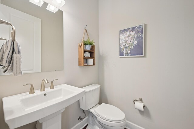 304 Cornelius St, Columbus, OH 43215 - half bathroom featuring toilet, baseboards, and a sink