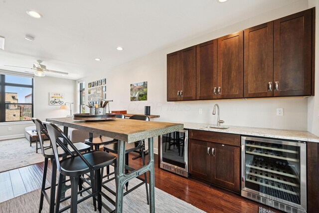304 Cornelius St, Columbus, OH 43215 - kitchen featuring wine cooler, a sink, dark brown cabinets, dark wood finished floors, and recessed lighting