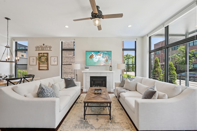 304 Cornelius St, Columbus, OH 43215 - living room featuring a ceiling fan, a tiled fireplace, recessed lighting, a chandelier, and wood finished floors