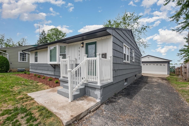 view of front of property with an outbuilding, a garage, board and batten siding, and fence