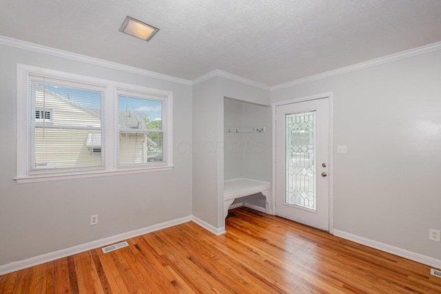 mudroom featuring baseboards, light wood-style flooring, ornamental molding, and a textured ceiling