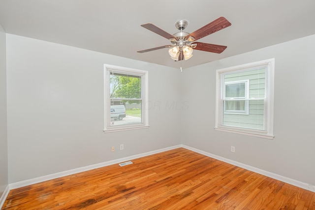 spare room featuring baseboards, light wood-style flooring, and a ceiling fan