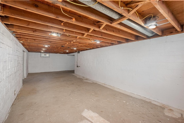 unfinished below grade area featuring concrete block wall