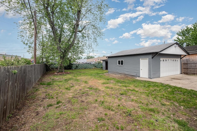 view of yard featuring a detached garage and an outbuilding