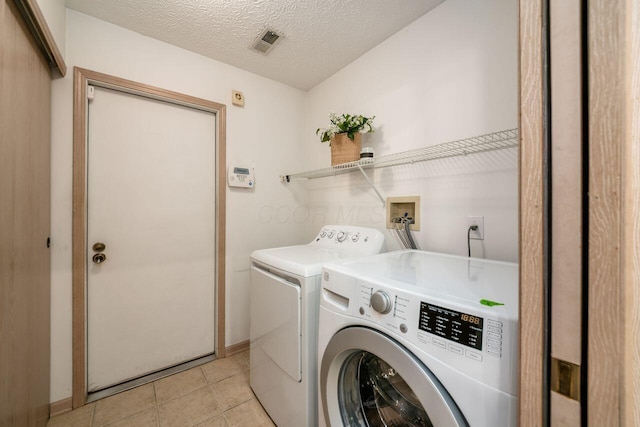 6323 Pinehurst Pointe, Westerville, OH 43082 - laundry room featuring washer and dryer, baseboards, light tile patterned floors, and a textured ceiling