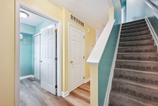 5210 Novelty Ave Unit 73D, Canal Winchester, OH 43110 - stairway featuring wood finished floors, a textured ceiling, and baseboards