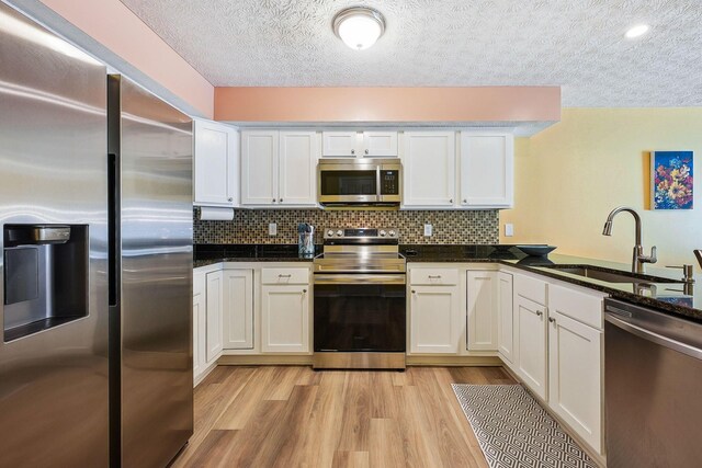 5210 Novelty Ave Unit 73D, Canal Winchester, OH 43110 - kitchen featuring stainless steel appliances, a sink, a textured ceiling, white cabinetry, and light wood finished floors
