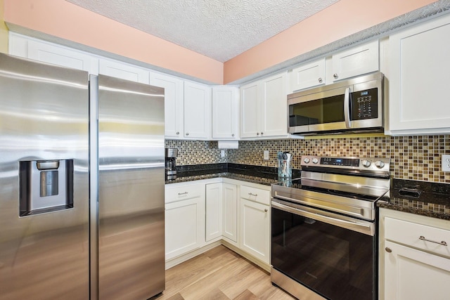 5210 Novelty Ave Unit 73D, Canal Winchester, OH 43110 - kitchen featuring appliances with stainless steel finishes, white cabinetry, backsplash, light wood-style flooring, and a textured ceiling