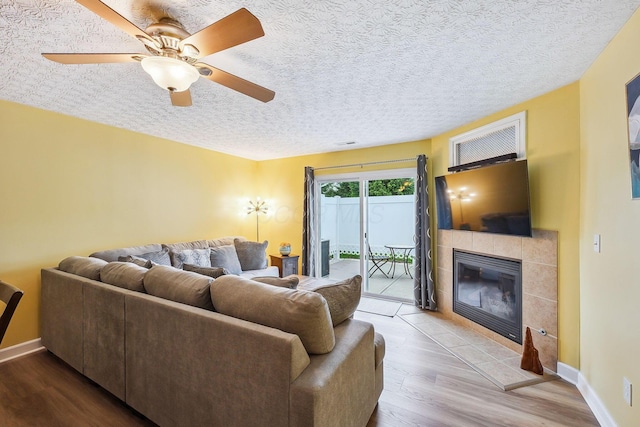 5210 Novelty Ave Unit 73D, Canal Winchester, OH 43110 - living room with wood finished floors, a fireplace, baseboards, ceiling fan, and a textured ceiling