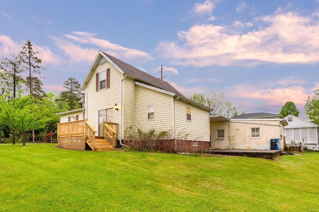 692 Millsboro Rd, Mansfield, OH 44903 - back of property at dusk featuring a lawn and a wooden deck