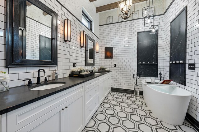 43-45 W Markison Ave, Columbus, OH 43207 - full bathroom with tile walls, double vanity, a freestanding tub, decorative backsplash, and tile patterned floors