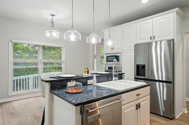1940 Scioto Pointe Dr, Columbus, OH 43221 - kitchen with stainless steel appliances, a kitchen island with sink, light wood-type flooring, a sink, and white cabinetry