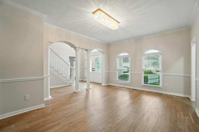 1940 Scioto Pointe Dr, Columbus, OH 43221 - spare room featuring arched walkways, ornate columns, stairs, hardwood / wood-style flooring, and ornamental molding