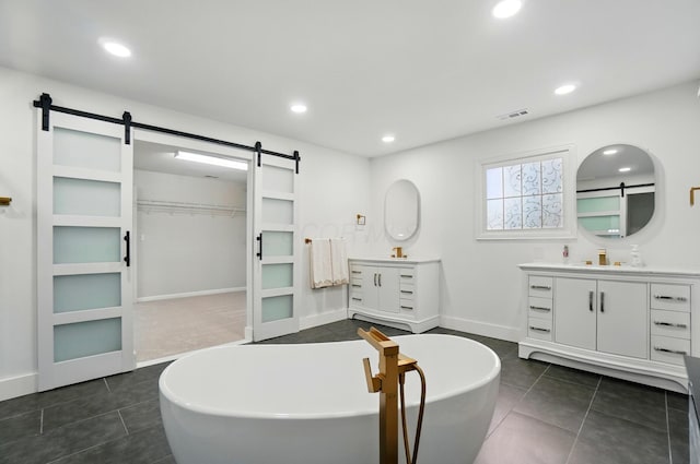 1940 Scioto Pointe Dr, Columbus, OH 43221 - full bathroom with two vanities, tile patterned flooring, recessed lighting, a freestanding bath, and a walk in closet