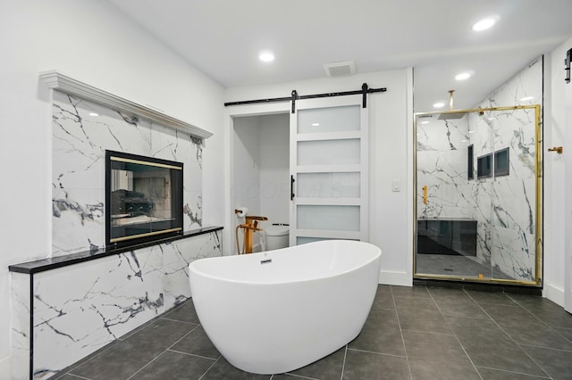 1940 Scioto Pointe Dr, Columbus, OH 43221 - bathroom with a marble finish shower, recessed lighting, a freestanding bath, tile patterned flooring, and a premium fireplace