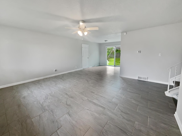 spare room with ceiling fan and baseboards