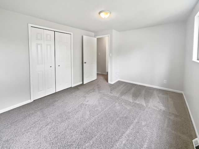 unfurnished bedroom with carpet, baseboards, and a closet