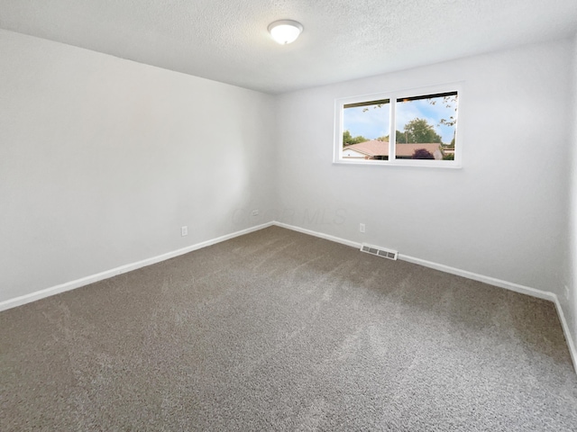 unfurnished room featuring dark colored carpet, baseboards, and a textured ceiling