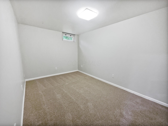 unfurnished room with baseboards and carpet floors