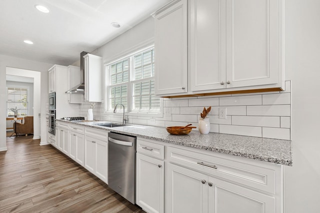 6039 Peck Ln, New Albany, OH 43054 - kitchen with appliances with stainless steel finishes, a sink, light wood-style floors, white cabinetry, and decorative backsplash