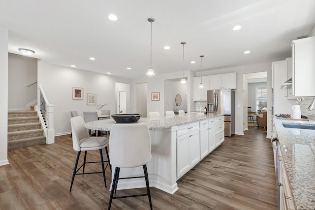 6039 Peck Ln, New Albany, OH 43054 - kitchen with stainless steel fridge with ice dispenser, wood finished floors, recessed lighting, a large island, and baseboards