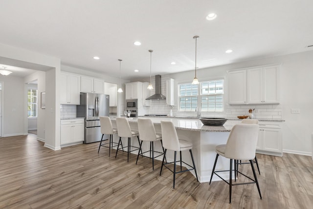6039 Peck Ln, New Albany, OH 43054 - kitchen with stainless steel appliances, wall chimney range hood, backsplash, light wood finished floors, and recessed lighting