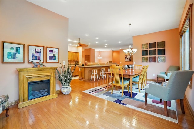 1092 George Allen Dr, South Vienna, OH 45369 - dining space with light wood-style floors, a chandelier, a glass covered fireplace, recessed lighting, and baseboards