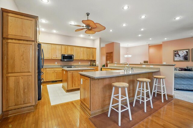 1092 George Allen Dr, South Vienna, OH 45369 - kitchen with a large island, stainless steel appliances, light wood-type flooring, a kitchen breakfast bar, and ceiling fan