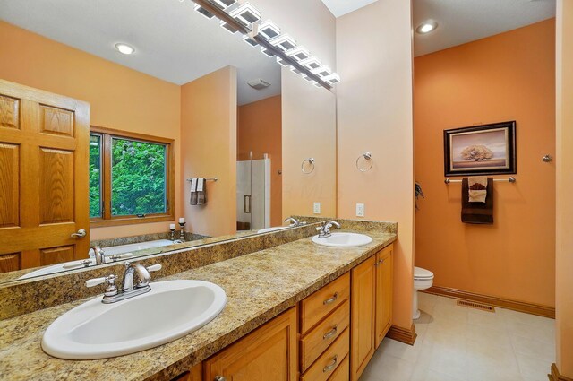 1092 George Allen Dr, South Vienna, OH 45369 - bathroom featuring toilet, double vanity, a garden tub, a shower stall, and baseboards