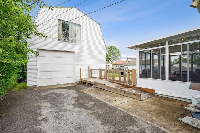 979 Westphal Ave, Columbus, OH 43227 - view of side of property with a sunroom, an attached garage, driveway, and a wooden deck
