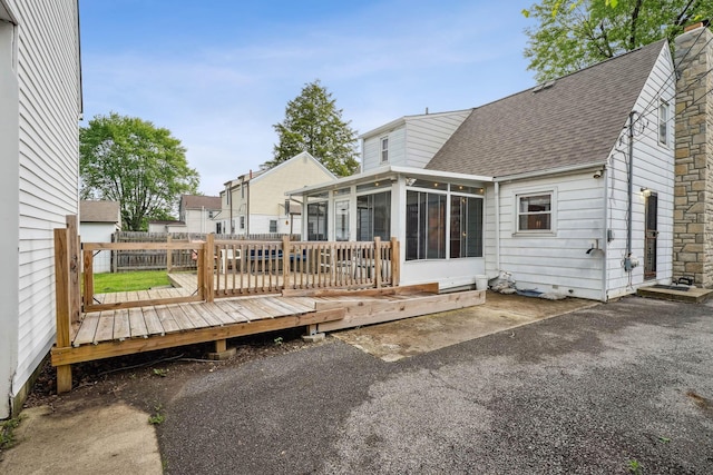 979 Westphal Ave, Columbus, OH 43227 - rear view of property featuring a shingled roof, a sunroom, a wooden deck, and a chimney