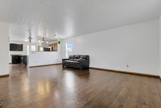 5504 Rothermund Dr, Canal Winchester, OH 43110 - living area featuring a textured ceiling, baseboards, and dark wood-style floors