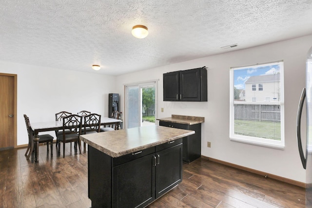 5504 Rothermund Dr, Canal Winchester, OH 43110 - kitchen featuring dark cabinetry, dark wood-style floors, baseboards, a textured ceiling, and a center island