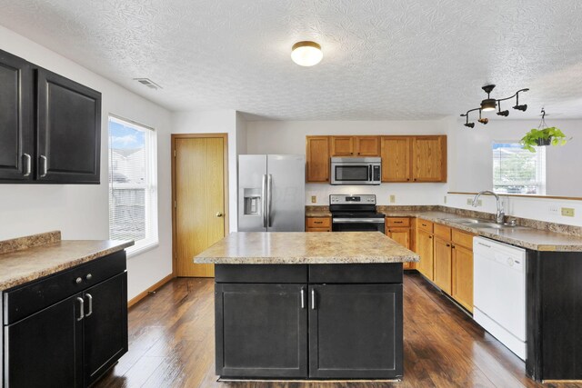 5504 Rothermund Dr, Canal Winchester, OH 43110 - kitchen featuring stainless steel appliances, a sink, dark cabinetry, a center island, and a textured ceiling