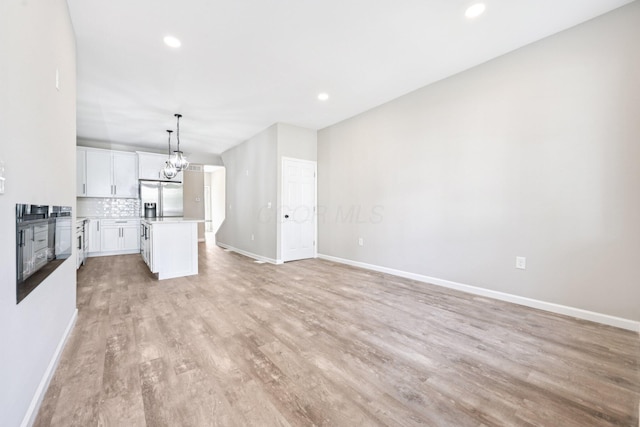 434 S Champion Ave, Columbus, OH 43205 - unfurnished living room with light wood-style flooring, a chandelier, and recessed lighting