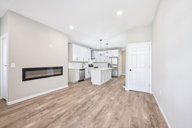434 S Champion Ave, Columbus, OH 43205 - unfurnished living room featuring light wood-style floors, a glass covered fireplace, recessed lighting, and a chandelier