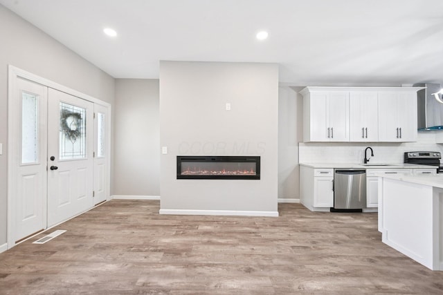 434 S Champion Ave, Columbus, OH 43205 - kitchen featuring appliances with stainless steel finishes, light countertops, white cabinetry, light wood finished floors, and tasteful backsplash