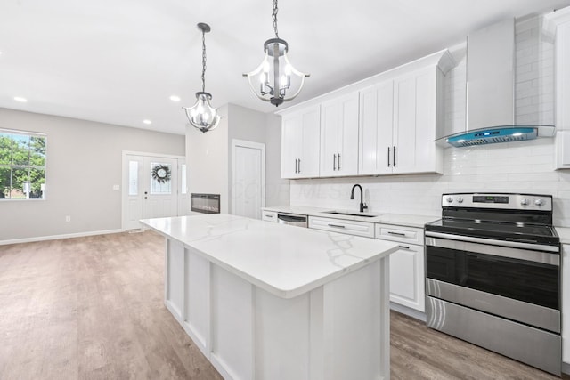 434 S Champion Ave, Columbus, OH 43205 - kitchen featuring stainless steel appliances, wall chimney exhaust hood, a chandelier, light wood-style flooring, and tasteful backsplash