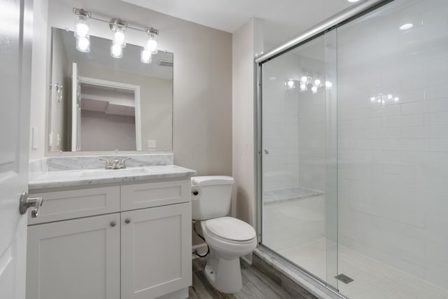 4526 Hoffman Farms Dr, Hilliard, OH 43026 - bathroom featuring a stall shower, toilet, vanity, and wood finished floors