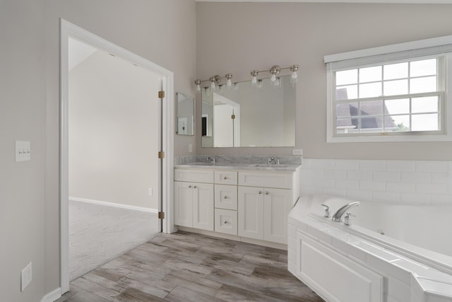 4526 Hoffman Farms Dr, Hilliard, OH 43026 - bathroom with a whirlpool tub, double vanity, wood finished floors, and baseboards
