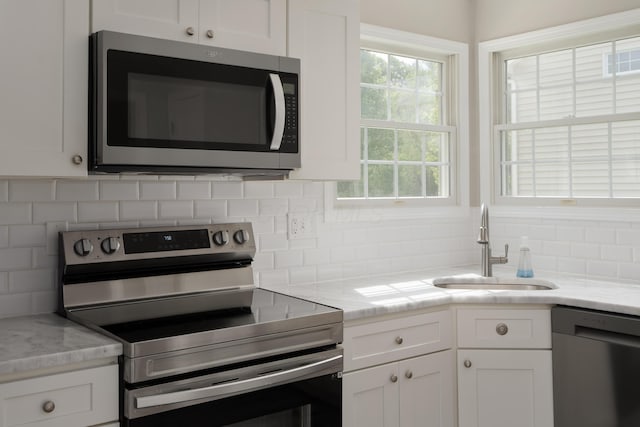 4526 Hoffman Farms Dr, Hilliard, OH 43026 - kitchen with appliances with stainless steel finishes, a sink, decorative backsplash, and white cabinets