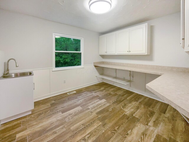 642 Ridenour Rd, Columbus, OH 43230 - washroom featuring a sink, light wood-style flooring, and a wainscoted wall