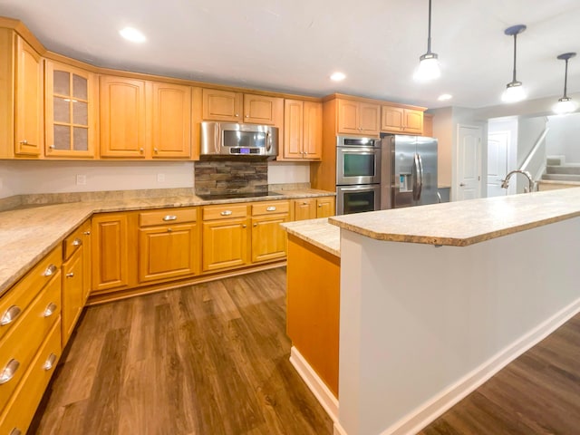 642 Ridenour Rd, Columbus, OH 43230 - kitchen featuring appliances with stainless steel finishes, dark wood-type flooring, glass insert cabinets, decorative light fixtures, and recessed lighting